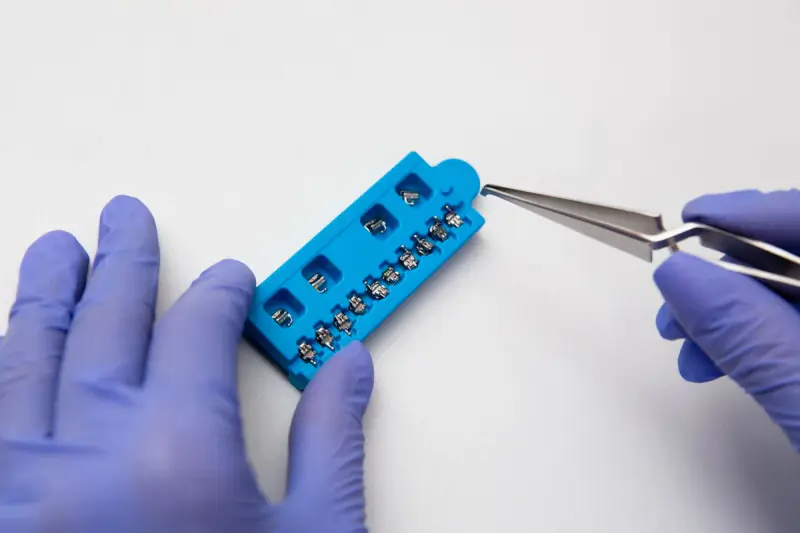 Brackets orthodontiques manipulés avec une pince