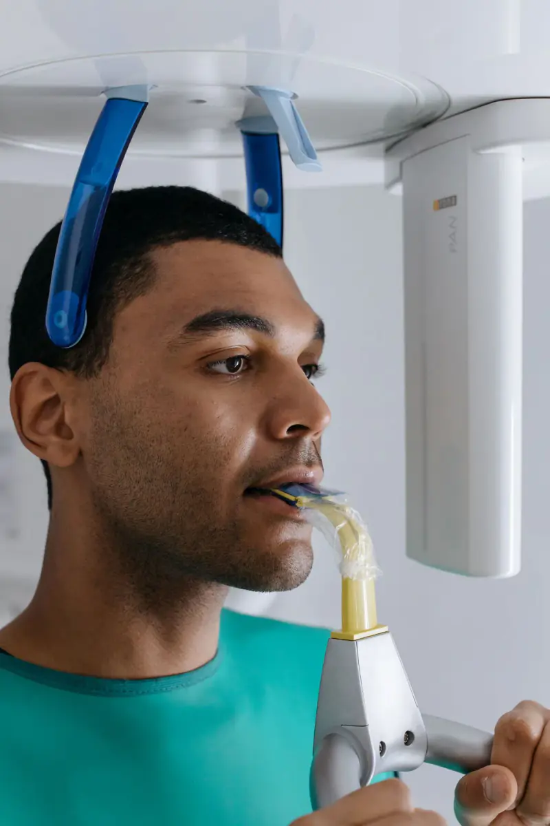Patient positionné dans un appareil de radiographie dentaire