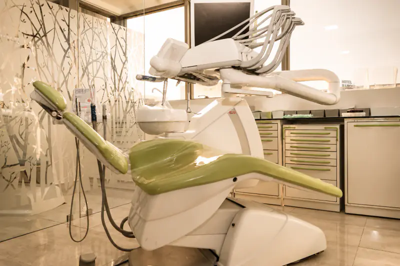 Fauteuil dentaire vert et console de soins utilisés en parodontologie au cabinet à Kénitra