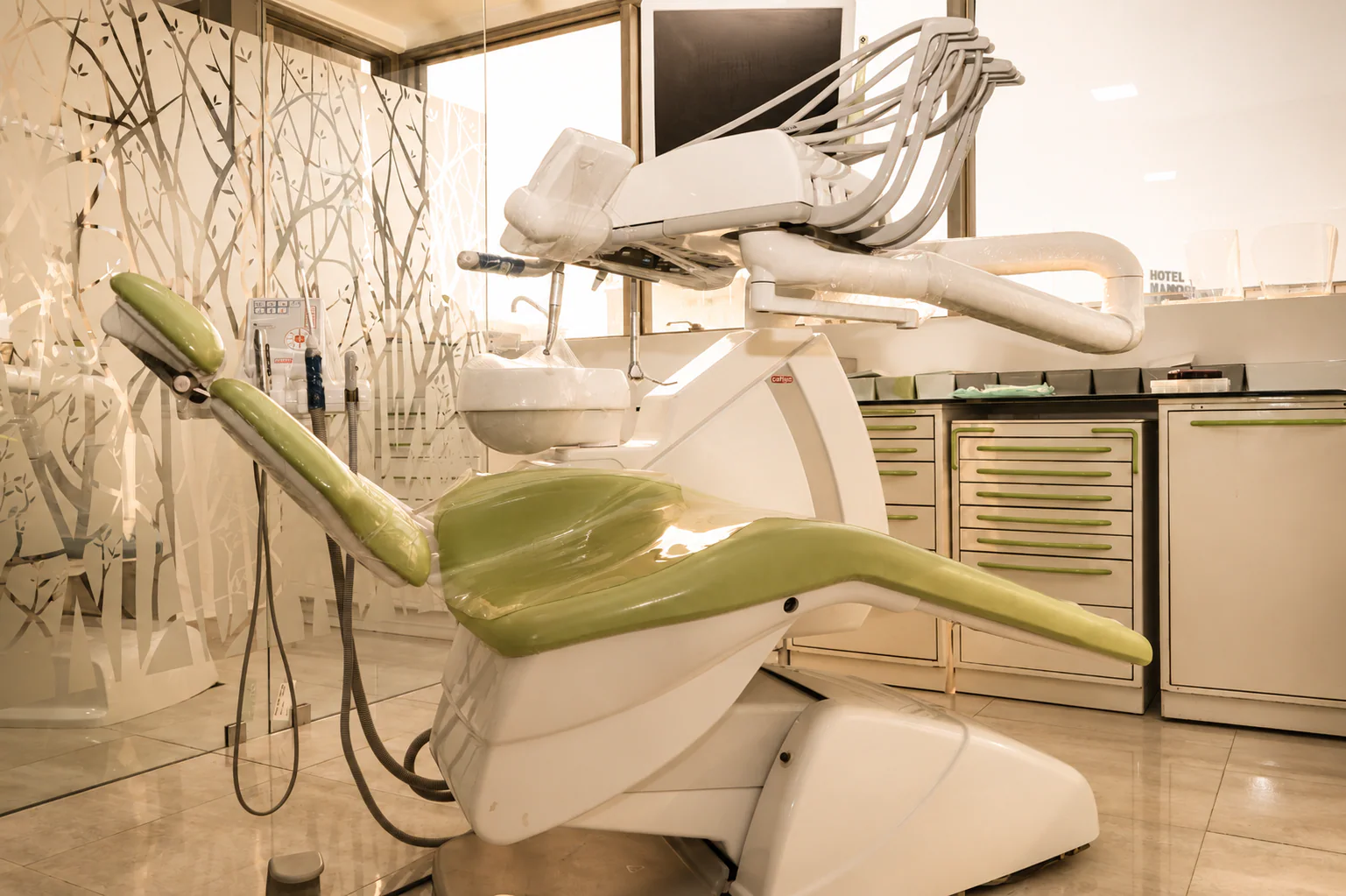 Fauteuil dentaire vert et console d'instruments dans une salle de parodontologie